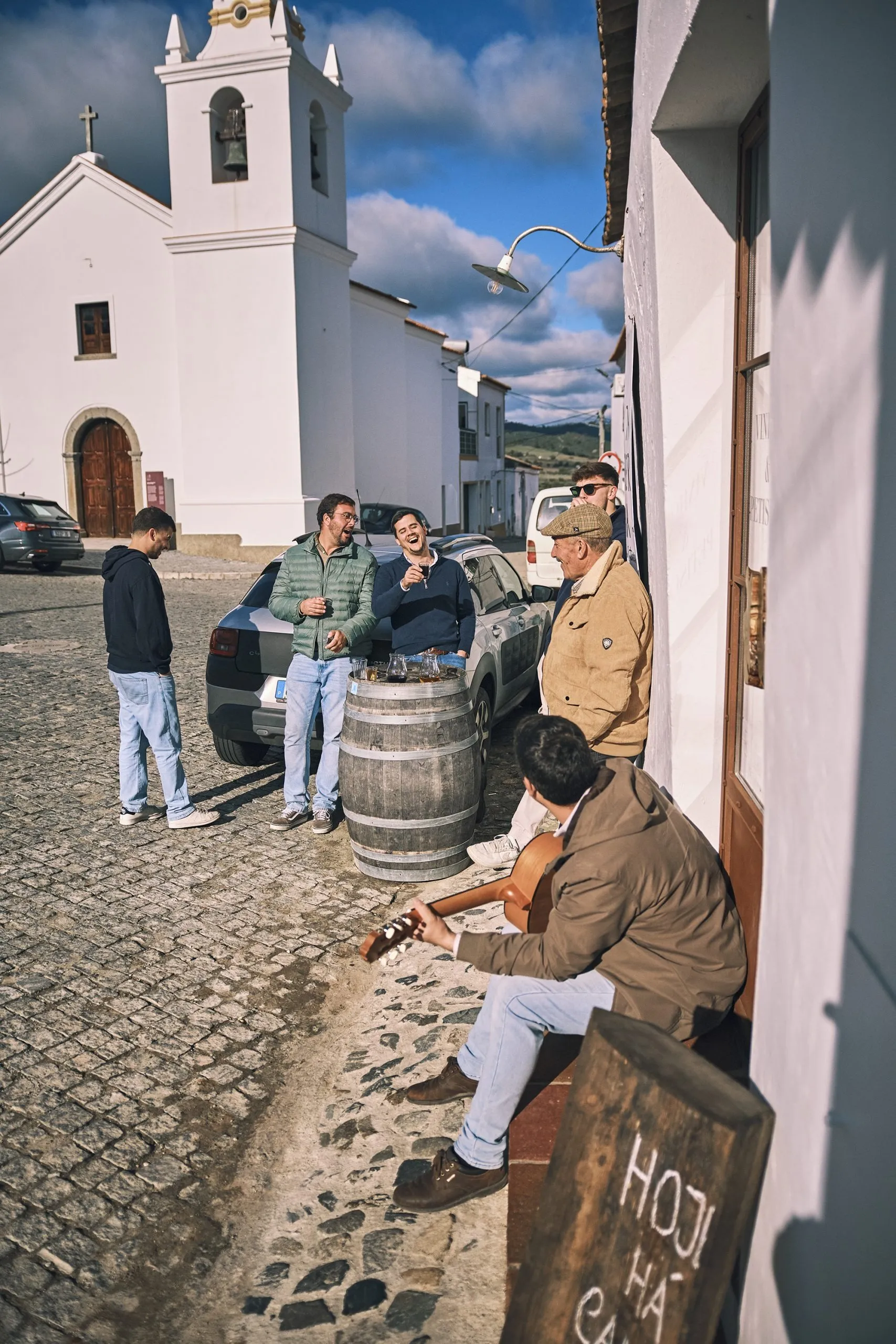Pessoas a conviver à porta da Taberna do Enteiriço em Vila de Frades com música e vinho
